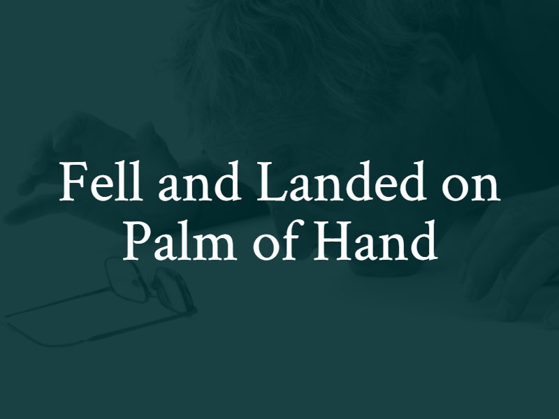 An elderly person falling and landing on their hand, with eyeglasses on the table and the text 'Fell and Landed on Palm of Hand' overlaying the image.