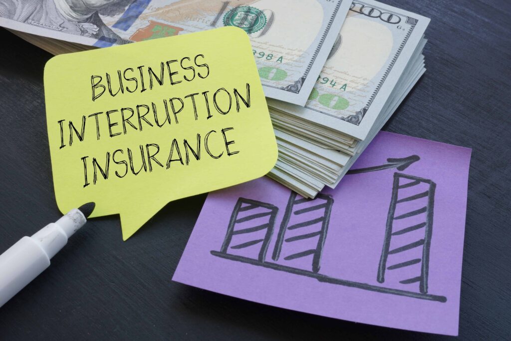 Business interruption insurance concept with cash stack, growth chart, and note highlighting coverage for lost income