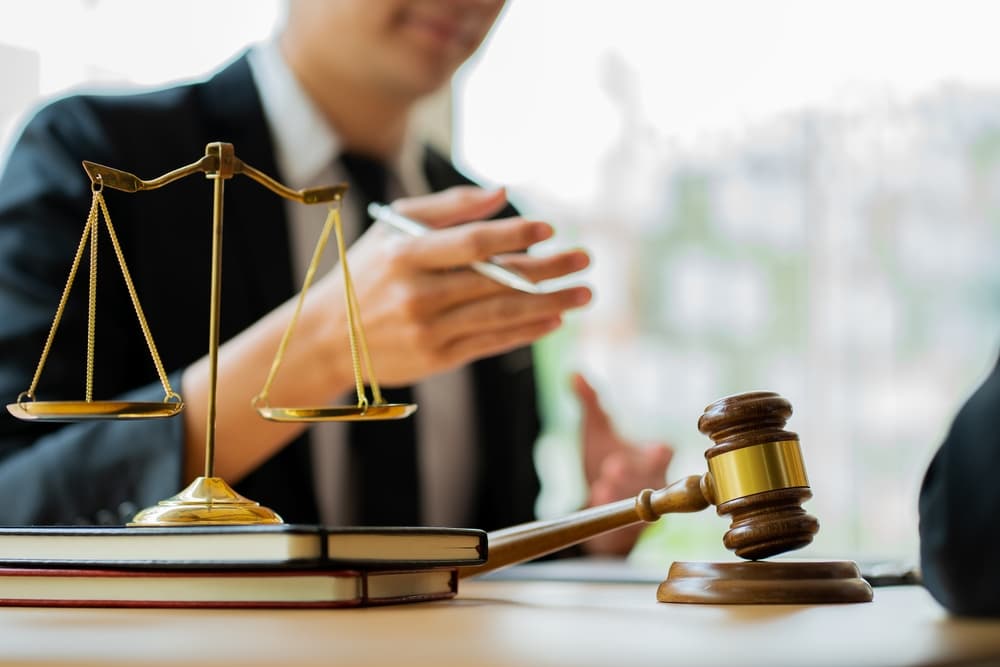 Lawyer providing legal services at a computer in the Labor Law Advising Office, with a desk featuring a hammer and scales symbolizing justice.