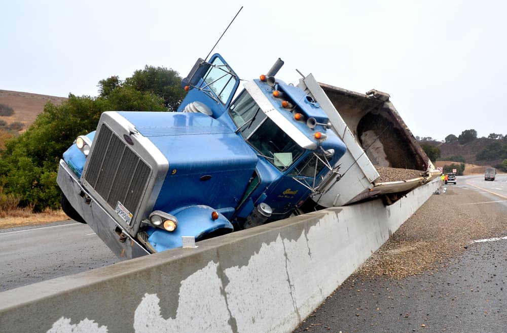 Overturned gravel truck on a slippery Buellton, California highway, a result of losing control in wet conditions.