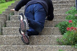 A woman slipping and falling down a staircase due to an accident.