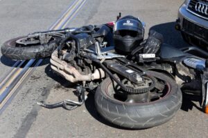 Collision scene: motorcycle collided with a car on the road.