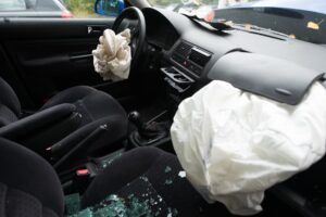 Car with deployed airbags after an accident, showing damage and safety features activated.