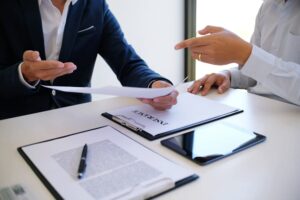 A sales manager reviewing an application form, providing guidance on loan options from a car insurance company.