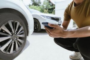 A busy road car accident scene with damaged vehicles, injured individuals, and responders assisting. The crash led to injuries and vehicle damage, prompting insurance claims and repair services.