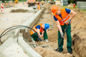 Two construction workers at a roadwork site.