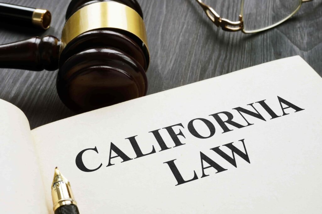 California law book with judge’s gavel and fountain pen on desk.