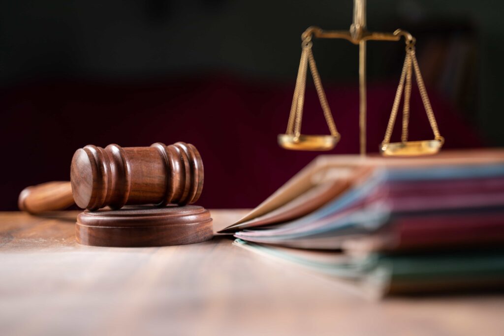 Judge’s gavel, legal documents, and scales of justice symbolizing law and courtroom decisions.
