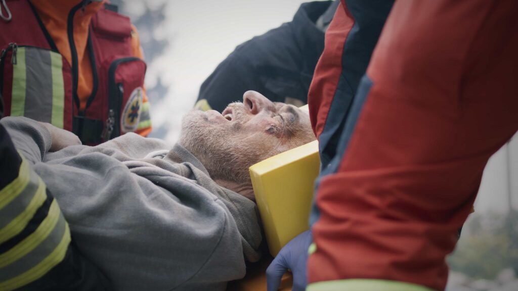 Injured man receiving emergency medical care after accident.