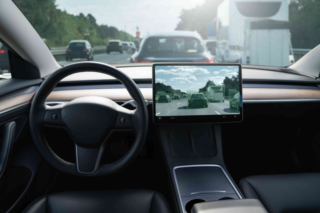 Autonomous car interior with self-driving system display showing traffic detection on highway.