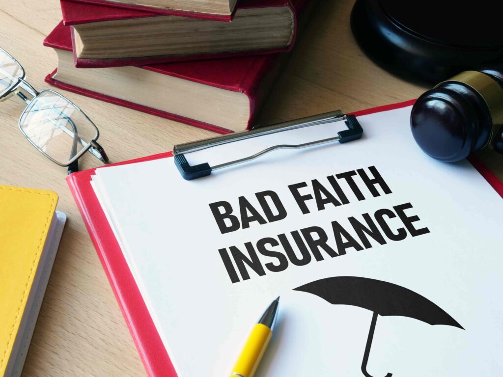 Bad faith insurance claim form with gavel, law books, and glasses on desk symbolizing insurance dispute and legal action.